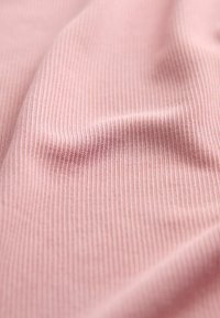 Țesătură ribbată de un roz deschis, cu o textură netedă, având linii verticale subtile și o cădere moale. Ideală pentru îmbrăcăminte sau tapițerie.