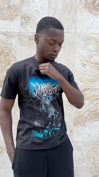 Tricou din bumbac negru, cu un design grafic ce include elemente albastre și albe reprezentând un schelet într-un peisaj de pădure. Stil cu gât în V, mâneci scurte.