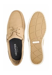 Lichtbruine leren bootschoenen met een gestructureerd oppervlak, een witte rubberen zool en tan accenten; voorzien van veters en het label "Hechter Paris."