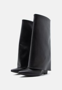 Fekete bőr boka csizmák egyedi magas szárú kialakítással. Vékony orruk és lapos talpuk modern, elegáns sziluettet alkot.