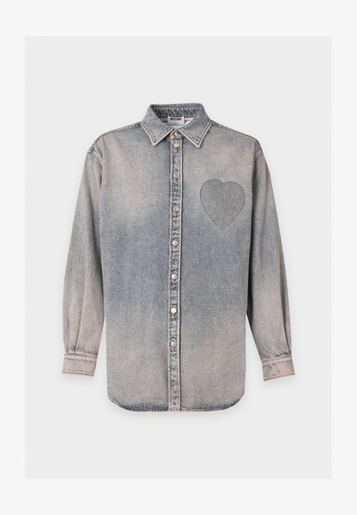 Chemise en denim gris à manches longues, avec un col et un cœur cousu sur le côté gauche de la poitrine.