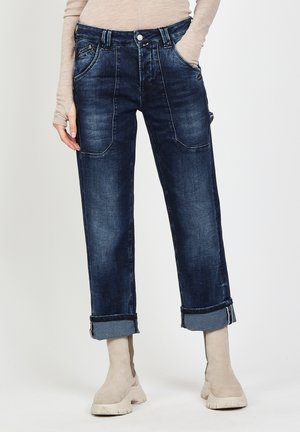 Dark blue jeans with a relaxed fit, featuring large front pockets, rolled cuffs, and subtle fading in the fabric texture.