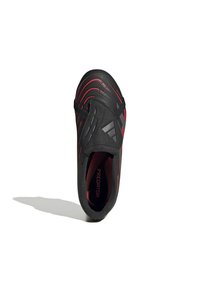 Schwarzer Sportschuh mit roten Akzenten, aerodynamisches Design, strukturierte Oberfläche und elastische Riemen für einen sicheren Sitz. Verfügt über internes Branding.