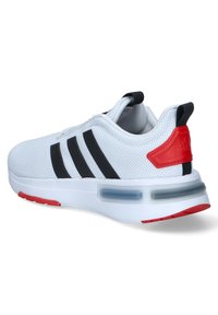 Baskets de sport blanches en mesh avec des rayures noires, des accents rouges et un panneau de rembourrage transparent au niveau du talon. Elles présentent un dessus texturé.