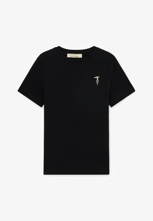 T-shirt noir à manches courtes et col rond avec un petit logo abstrait beige sur le côté gauche de la poitrine et une étiquette blanche à l'intérieur du col.