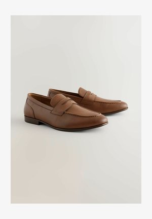 Mocassini in pelle marrone dalla texture liscia, con tacco piatto, dettagli cuciti e una fascia decorativa sulla parte superiore.