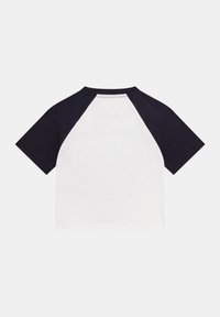 Camiseta de manga corta tipo raglán con cuerpo blanco y mangas azul marino. Confeccionada en una tela suave, con cuello redondo y costuras en contraste.