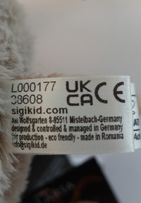 Label on soft, beige fabric with black printed text. Includes product details, company information, and certifications like UKCA and CE.