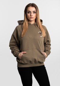 Olivově zelená mikina s kapucí, s přední kapsou, šňůrkou na stažení a žebrovanými manžetami. Na levé straně hrudi má malé logo zobrazující strom.