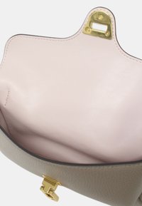 Sac à main en cuir avec un extérieur gris texturé, quincaillerie dorée et un intérieur rose lisse. Détail de fermeture visible en haut.