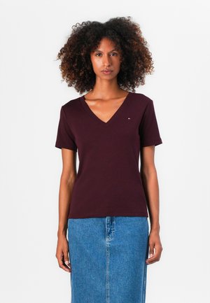 Bordeaux V-hals t-shirt van katoen, korte mouwen, gecombineerd met een spijkerrok. Bevat een klein geborduurd logo op de borst.