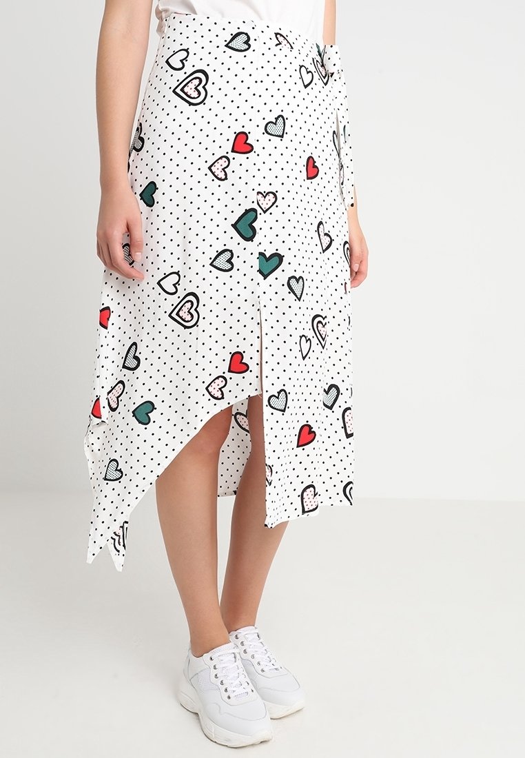 Gonna asimmetrica bianca con pois neri e motivi a cuore colorati in rosso, verde e rosa. Realizzata in tessuto leggero.