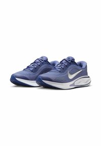 Scarpe sportive viola con tomaia in mesh testurizzato, collo imbottito e suola intermedia bianca. Presenta il logo Nike in argento sul lato.