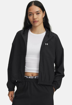 Black zip-up jacket with a hood and elastic cuffs, featuring a sleek design. The fabric appears smooth, with an Under Armour logo on the chest.