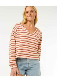 Pullover a righe nei toni del rosa, marrone e crema, con scollo a V e maniche lunghe. Indossato con pantaloni shorts di jeans, caratterizzati da una vestibilità comoda.