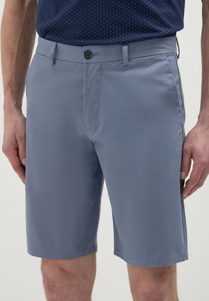 Shorts bleu clair avec une fermeture à bouton sur le devant, passants de ceinture et poches latérales ; texture lisse et coupe ajustée pour un look décontracté.