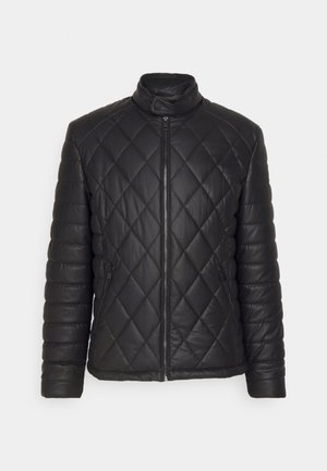 Giacca trapuntata nera con collo alto, zip frontale e tasche laterali. Presenta una texture liscia e imbottita con motivo a diamante.