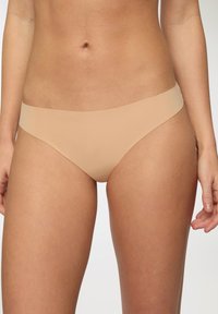 Slip bikini a vita bassa color nudo con un design liscio e senza cuciture. Materiale morbido e elastico con una cintura larga. Copertura minima e senza cuciture visibili.
