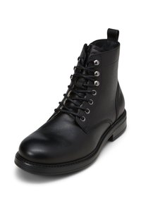 Stivale alla caviglia in pelle nera con punta rotonda, superficie testurizzata, occhielli in metallo e lacci robusti. Include un tassello sul tallone e cuciture decorative.