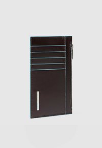 Donkerbruine leren kaarthouder met blauwe stiksels, voorzien van vijf kaartsleuven en een zakje met ritssluiting aan de zijkant. Gladde textuur.