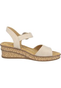 Sandalias de cuña beige con una base de corcho texturizada, punta abierta y correa ajustable. Material superior suave con un acento redondo en la correa.