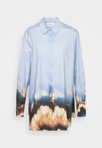 Light blue long-sleeve shirt, featuring a button-down front, with a gradient pattern transitioning to dark brown at the hem. Smooth fabric texture.