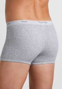 Boxer in cotone grigio con una soffice cintura elastica che presenta un logo. La texture è liscia e la vestibilità è aderente.