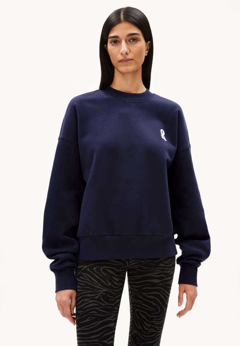 Navy blue sweatshirt made of cotton blend, featuring a crew neck, dropped shoulders, and a small white ribbon logo on the chest.