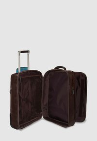 Brauner Trolley-Koffer mit silbernem Griff, ausgestattet mit zwei Reißverschlussfächern, eines davon mit Netzabdeckung, und einem einfarbigen Innenraum.