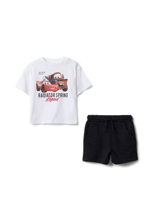 T-shirt blanc en coton avec un imprimé de personnage et le texte « RADIATOR SPRING Legend », associé à un short noir en coton avec poches et cordon de serrage.