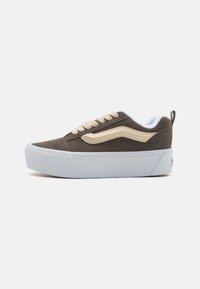 Brown suede sneaker featuring a white rubber sole, cream accent stripe, and beige laces, with perforations on the upper for ventilation.