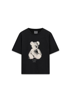 T-shirt noir avec un ours en peluche blanc en style croquis et le texte "GUESS 1981" imprimé sous l’ours sur la poitrine.
