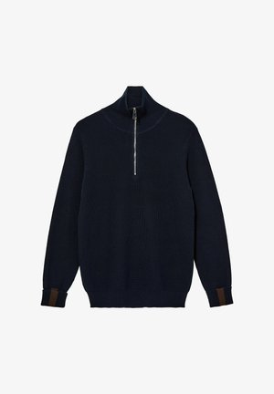 Temno modra pletena jopica z visokim ovratnikom, ki ima četrtni zadrgo in kontrastne rjave črte na manšetah. Mehka tekstura.