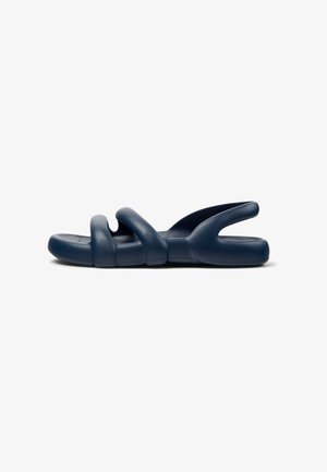 Navy blue slide sandals with three curved straps, made of flexible material, featuring a textured sole for grip and comfort.