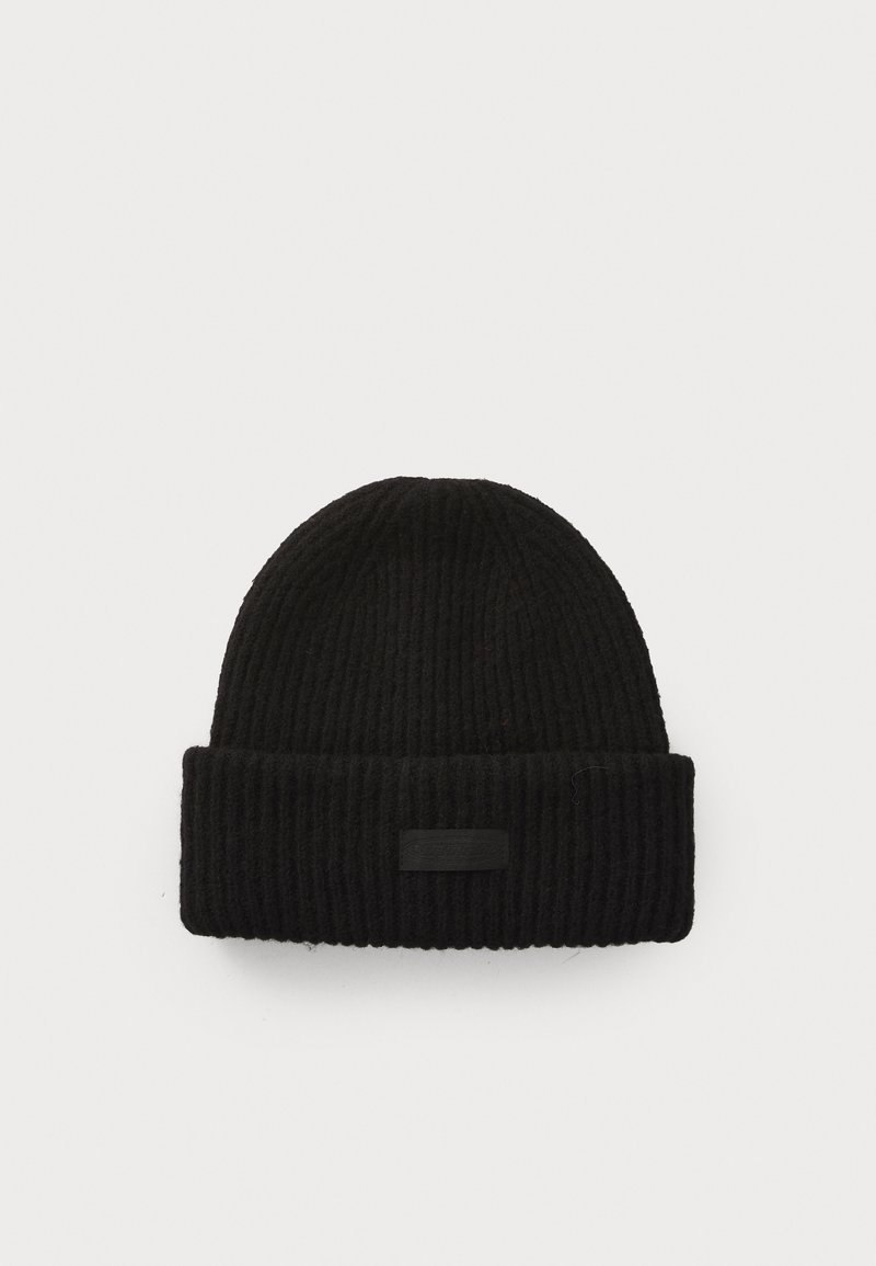 Beanie negru cu dungi, din tricot, având o margine răsturnată. Prezentând un mic etichetă neagră pe margine, care evidențiază un material texturat și un design strâns.