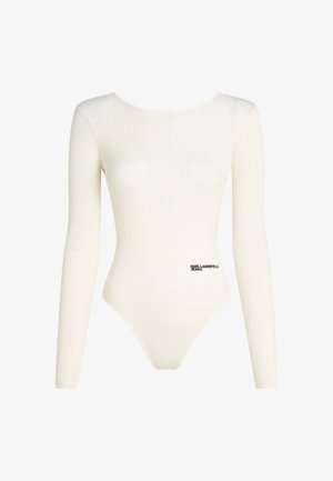Body de manga larga acanalado en color crema, con escote redondeado y un logo de la marca en negro en la parte inferior. El diseño ajustado realza la figura.