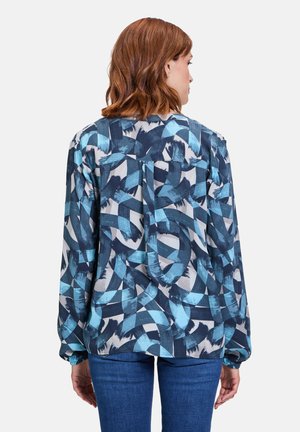 Flowy blouse in blue and gray abstract pattern, lightweight fabric, long sleeves with gathered cuffs, back neckline with loop detail.