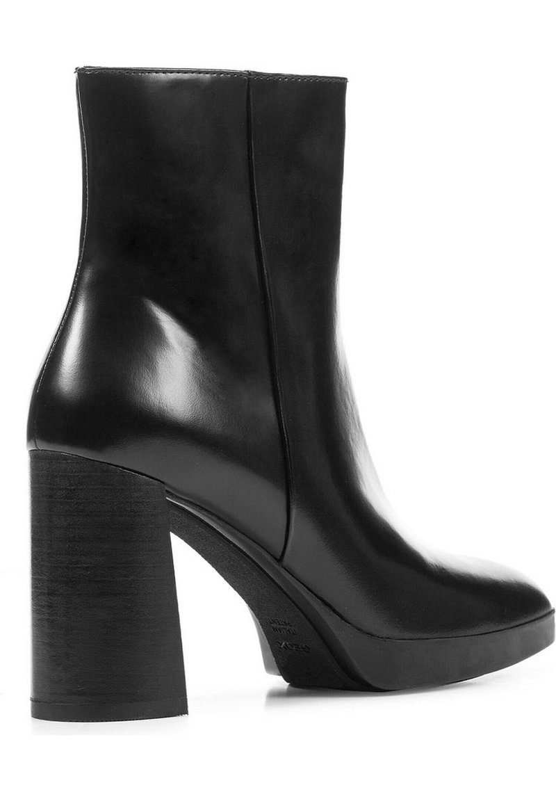 Bottine en cuir noir avec une finition lisse et brillante, un haut talon bloc et un design minimaliste, présentant une texture extérieure lisse.