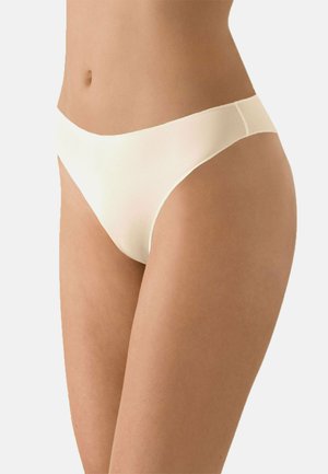 Cream-colored thong with a seamless design, made of smooth, lightweight fabric; features a low-rise waistband and minimal coverage.