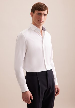 Witte overhemd met een contrasterende gepatterneerde kraag, fitted ontwerp, lange mouwen, en donkere broek, met strakke lijnen en soepele stof.
