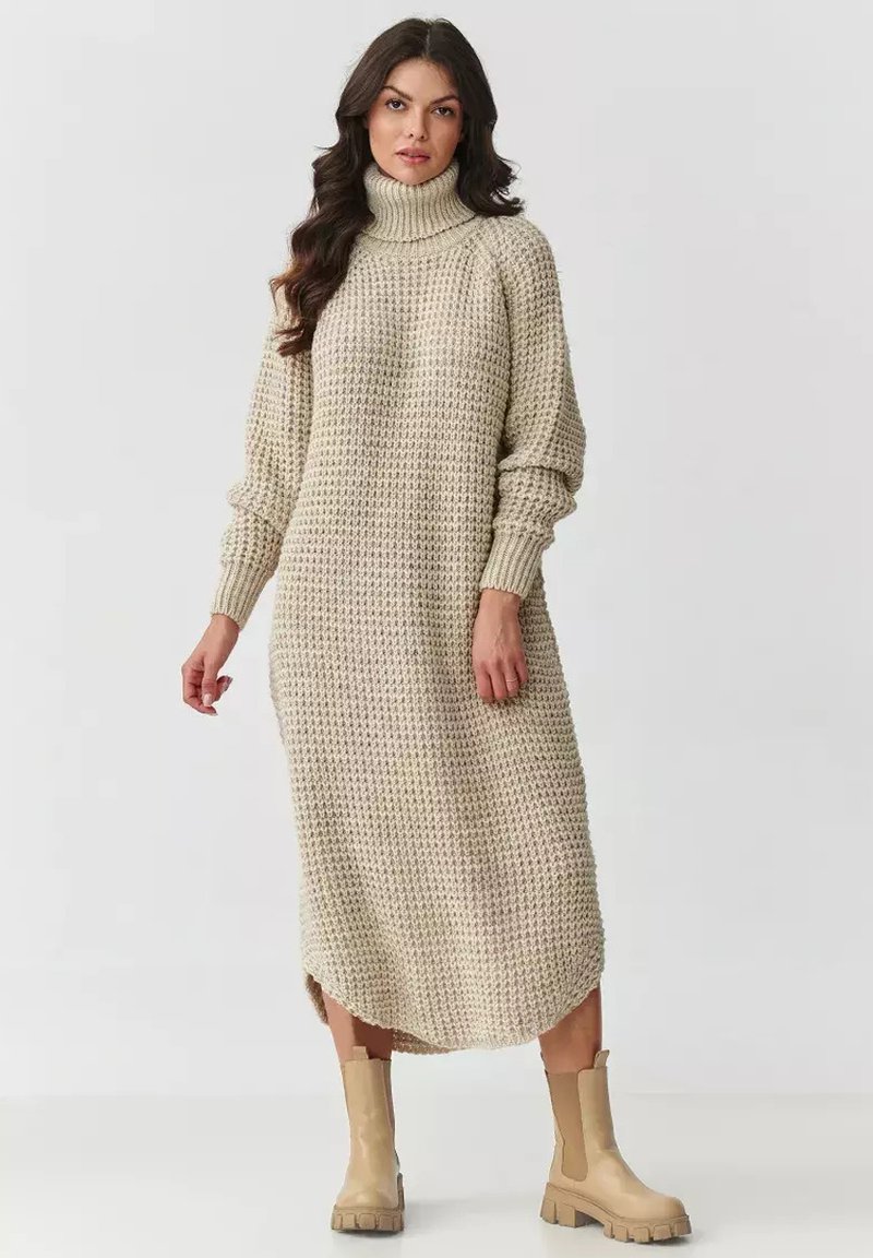 Sukienka dzianinowa z golfem w jasnym beżu, z teksturowanym wzorem, długimi rękawami i bocznymi rozcięciami; w połączeniu z beżowymi botkami za kostkę.