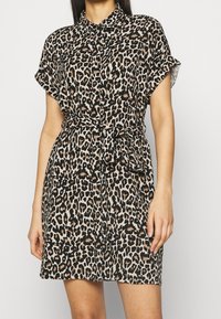 Sukienka koszulowa w print w panterkę, wykonana z lekkiego materiału, z kołnierzykiem, krótkimi podwiniętymi rękawami i pasem w talii.