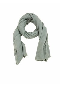 Écharpe en tricot gris clair et doux, légèrement bouclée avec des bords effilochés, présentée sur un fond blanc.