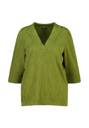 Blouse verte texturée à manches longues avec encolure en V et motif ondulé subtil, taille moyenne.