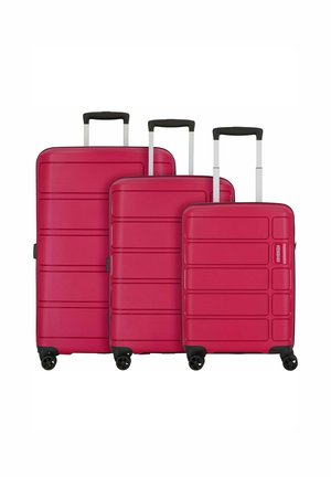 Set di tre valigie rigide di colore rosa vivace, con design a pannelli verticali, maniglie retrattili e ruote multidirezionali.