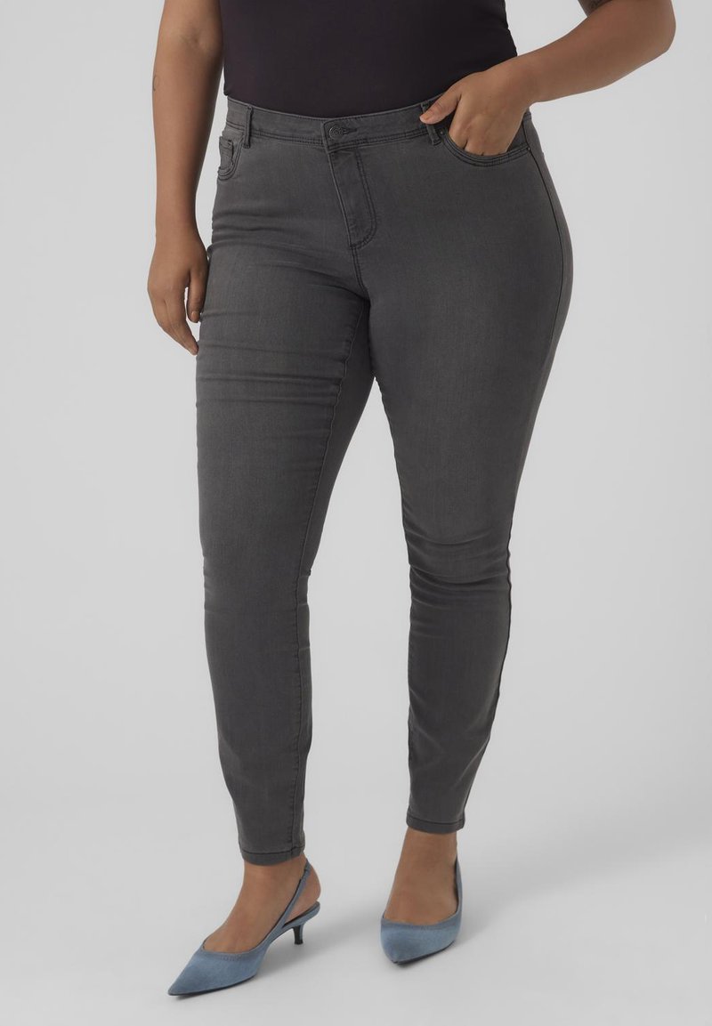 Dark grey skinny jeans made of stretchy cotton blend fabric, featuring five pockets, belt loops, and a zip fly with button closure.