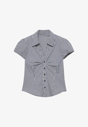 Blouse à manches courtes à carreaux bleus et blancs avec des boutons sur le devant et un col pointu, posée à plat sur un fond blanc.