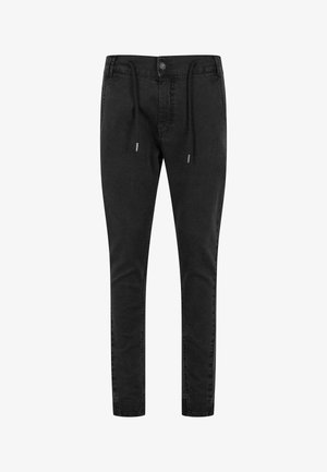 Mustad mustad püksid, valmistatud pehmest denimist, kitseneva lõikega, elastse nööriga sääreosas ja hõbedast detailidega.