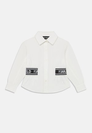 White long-sleeve shirt with a button-down collar, featuring black elastic bands at the waist with "KARL" branding. Smooth fabric texture.