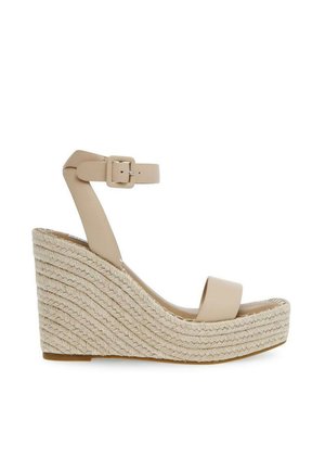 Sandalia cuña beige con suela plataforma tejida, correa en el tobillo con hebilla cuadrada y diseño de punta abierta.